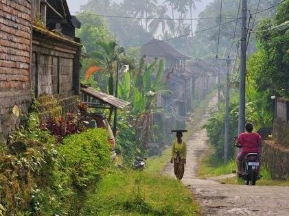 Woman walking in small street in village, Bali