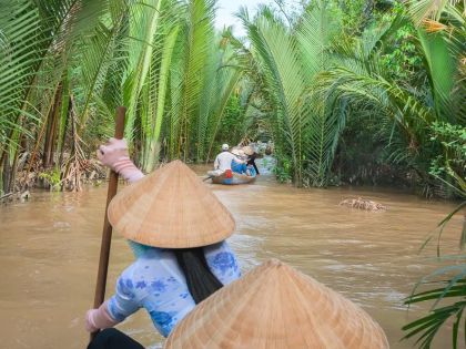 Vietnamese woman paddling in the Mekong River